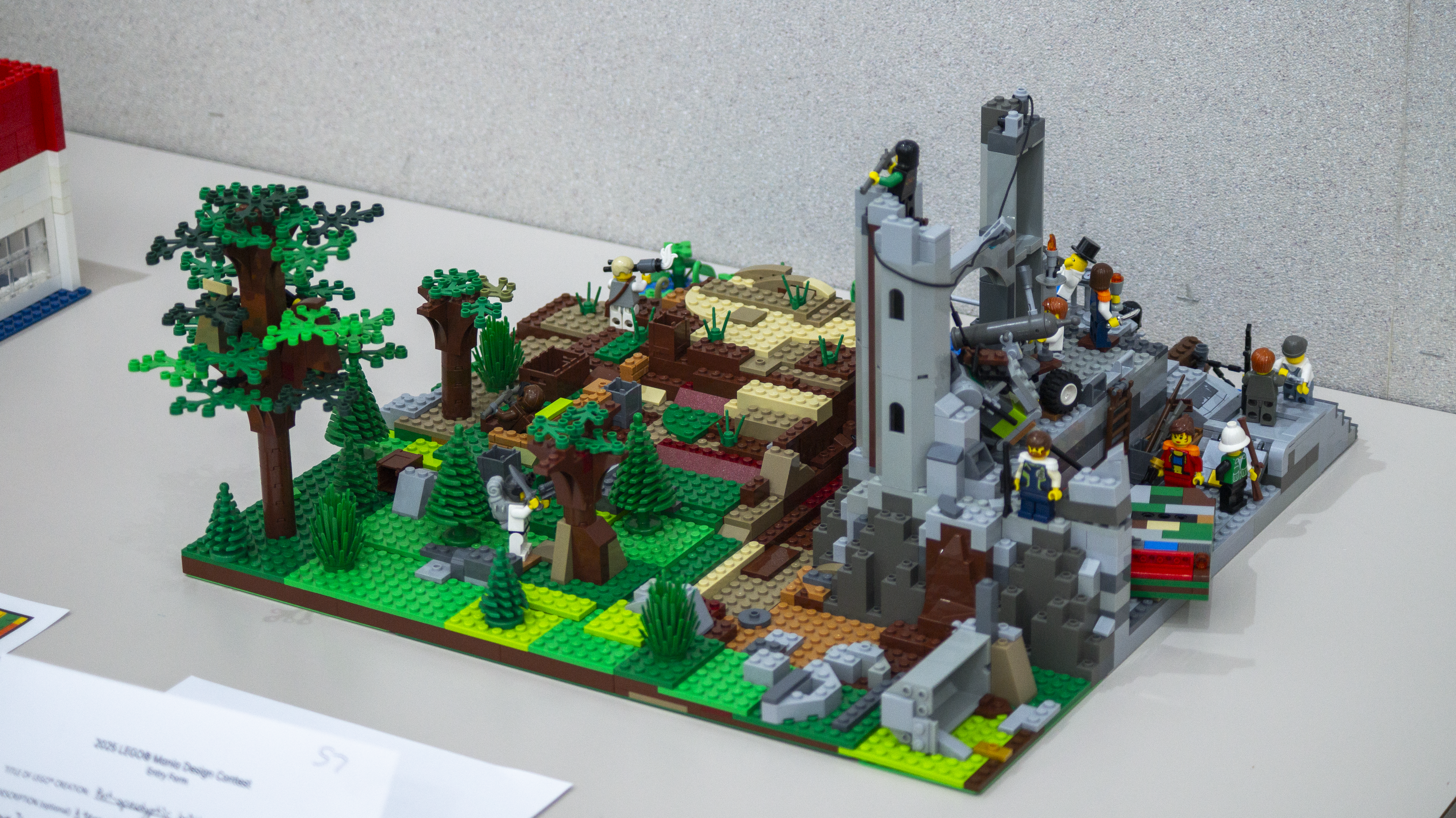 A scene showing a battle. One half is forested and the second half is a stone fortress.