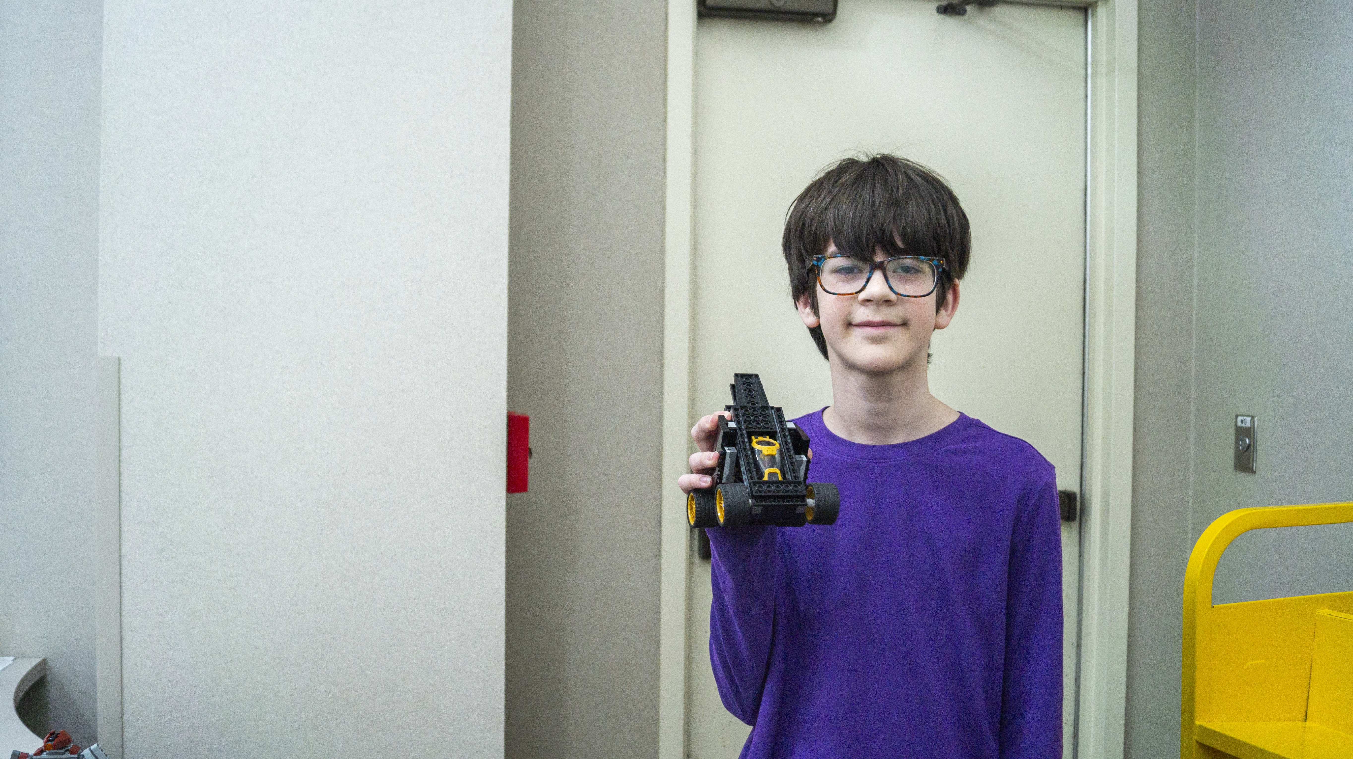 A boy holding his Lego transformer vehicle.