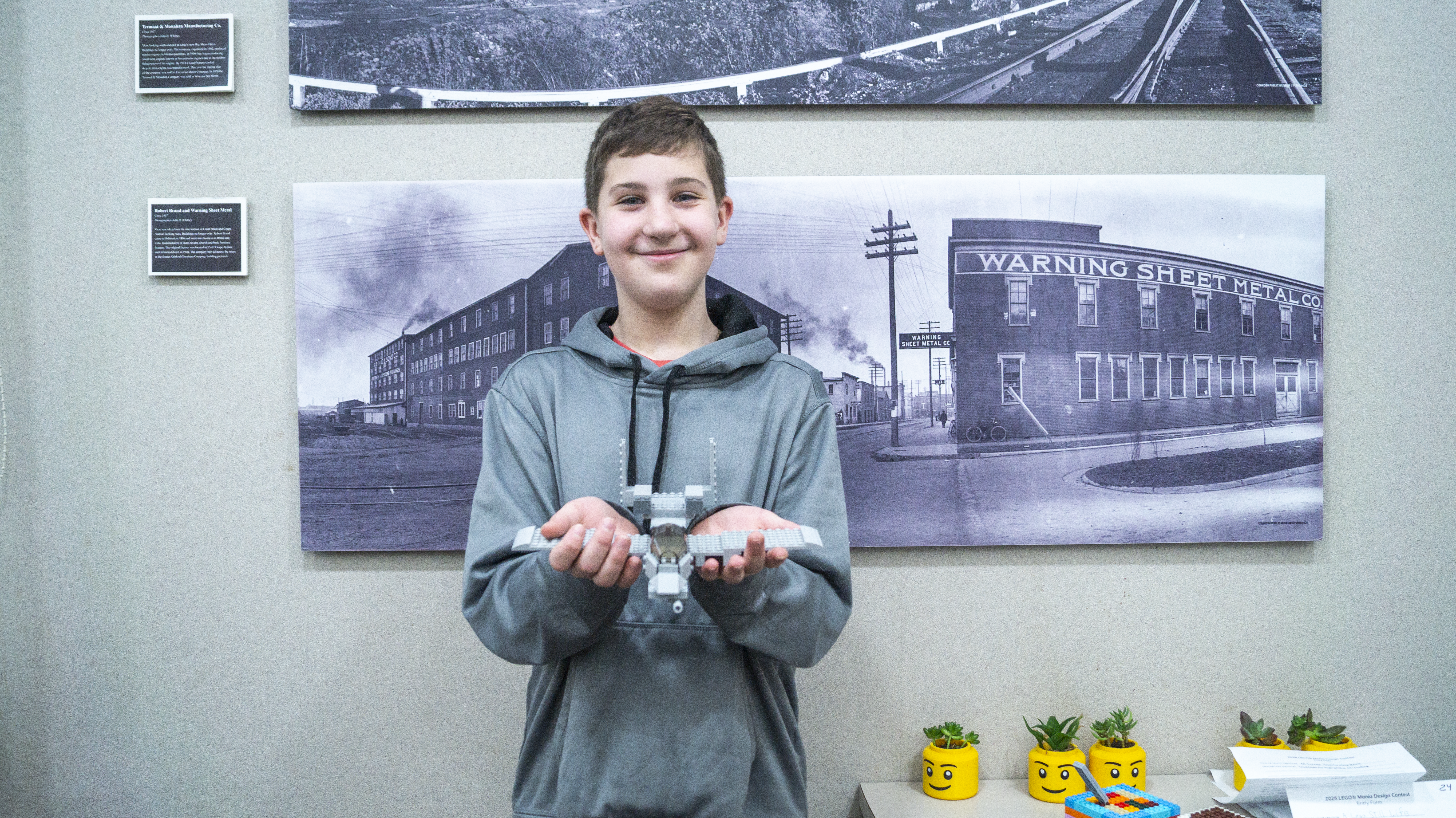 A boy holding his Lego plane creation