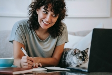 woman and cat looking at a computer