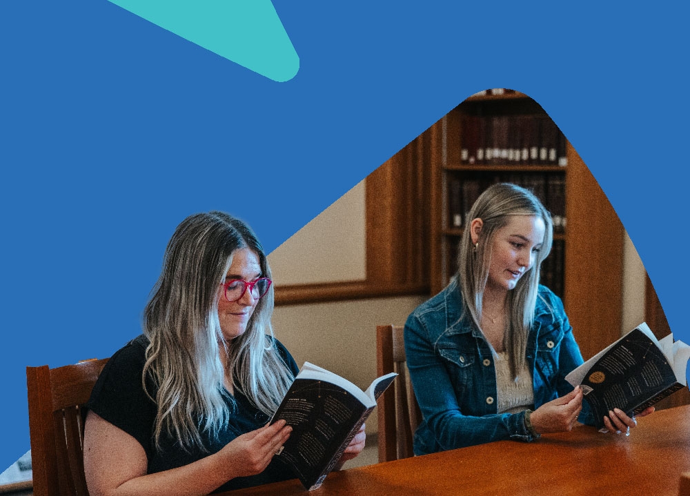Two people focused on their books. 